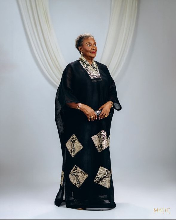 Chief Mrs. Josephine Chinyelu Nwosu standing in a black outfit with patterned details.