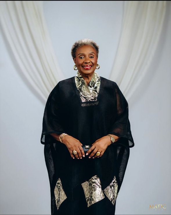 Chief Mrs. Josephine Chinyelu Nwosu smiling in a black outfit with a patterned collar.
