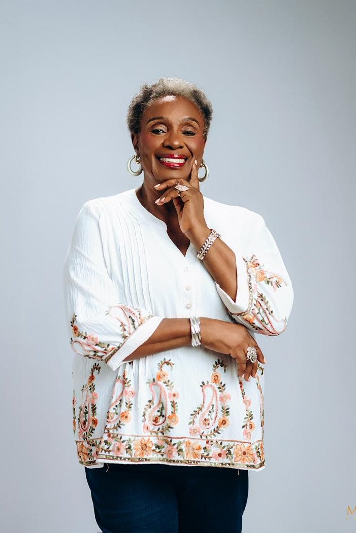 Chief Mrs. Josephine Chinyelu Nwosu smiling in a white floral blouse.