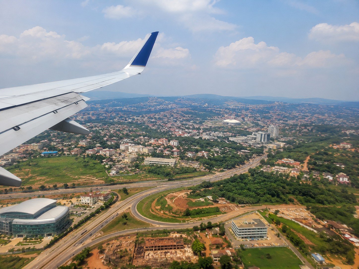 Aerial view of a city from an airplane window, echoing the travel artwork from the reference site.